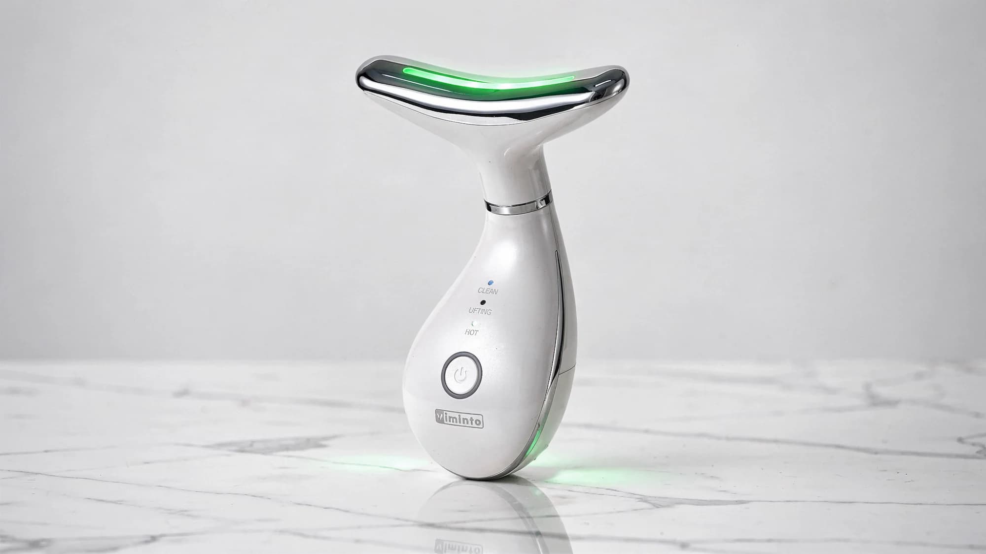 VIMINTO 3-in-1 Face Massager on a marble countertop with green LED therapy mode activated