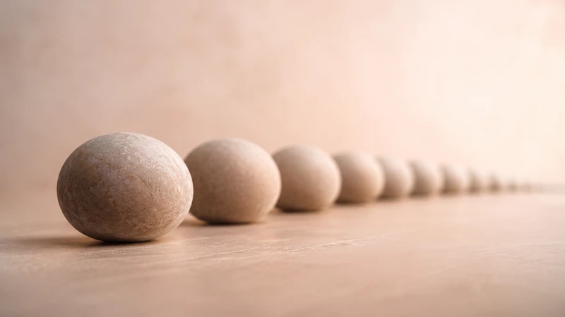 One smooth stone beside a receding row of stones, symbolizing a single at-home purchase versus recurring clinic costs